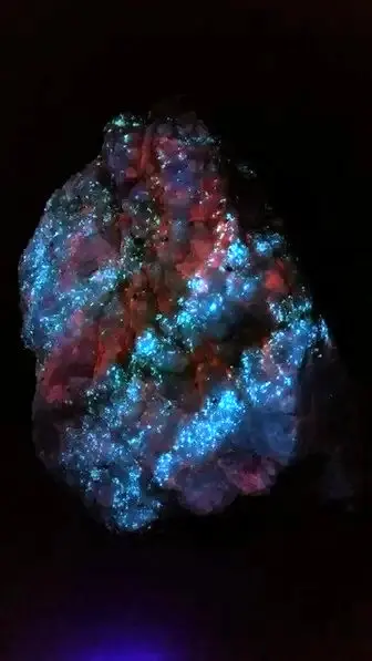 Experience the fluorescent beauty of hydrozincite and calcite!